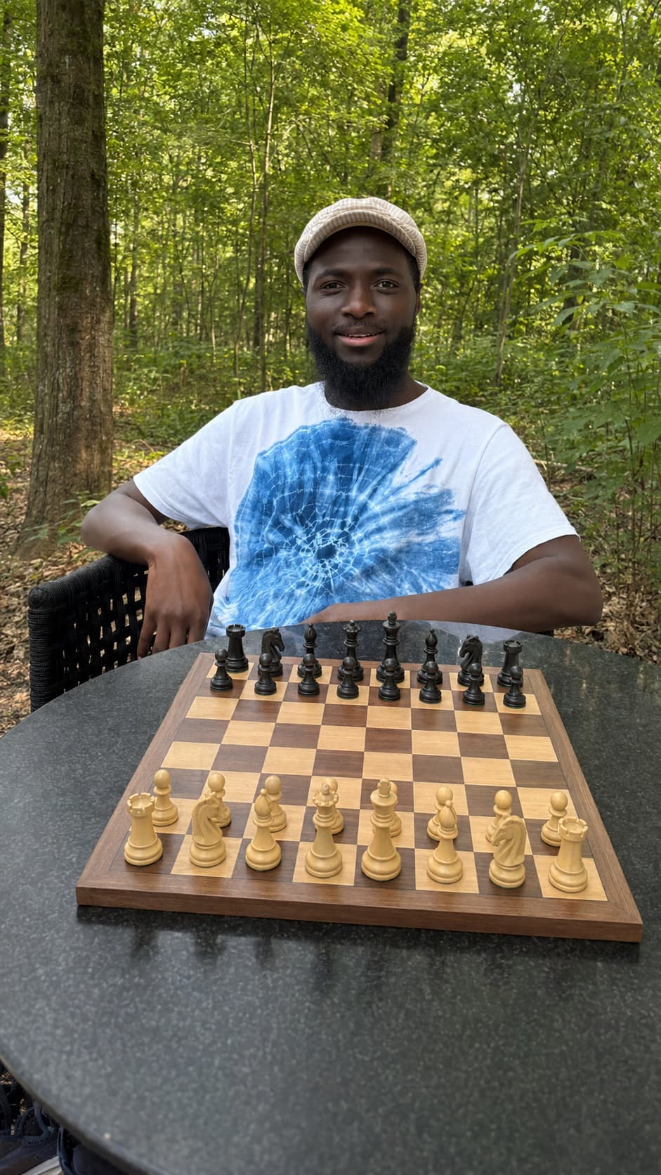 Coach Rodolfo Machirica sitting in a garden with a chessboard